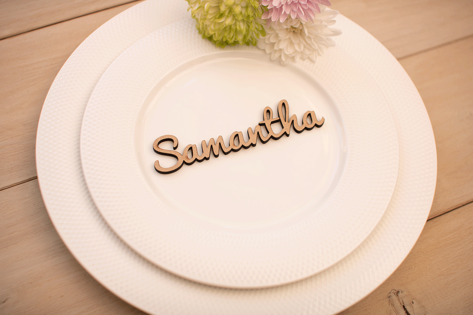 A wooden wedding placename on a white plate